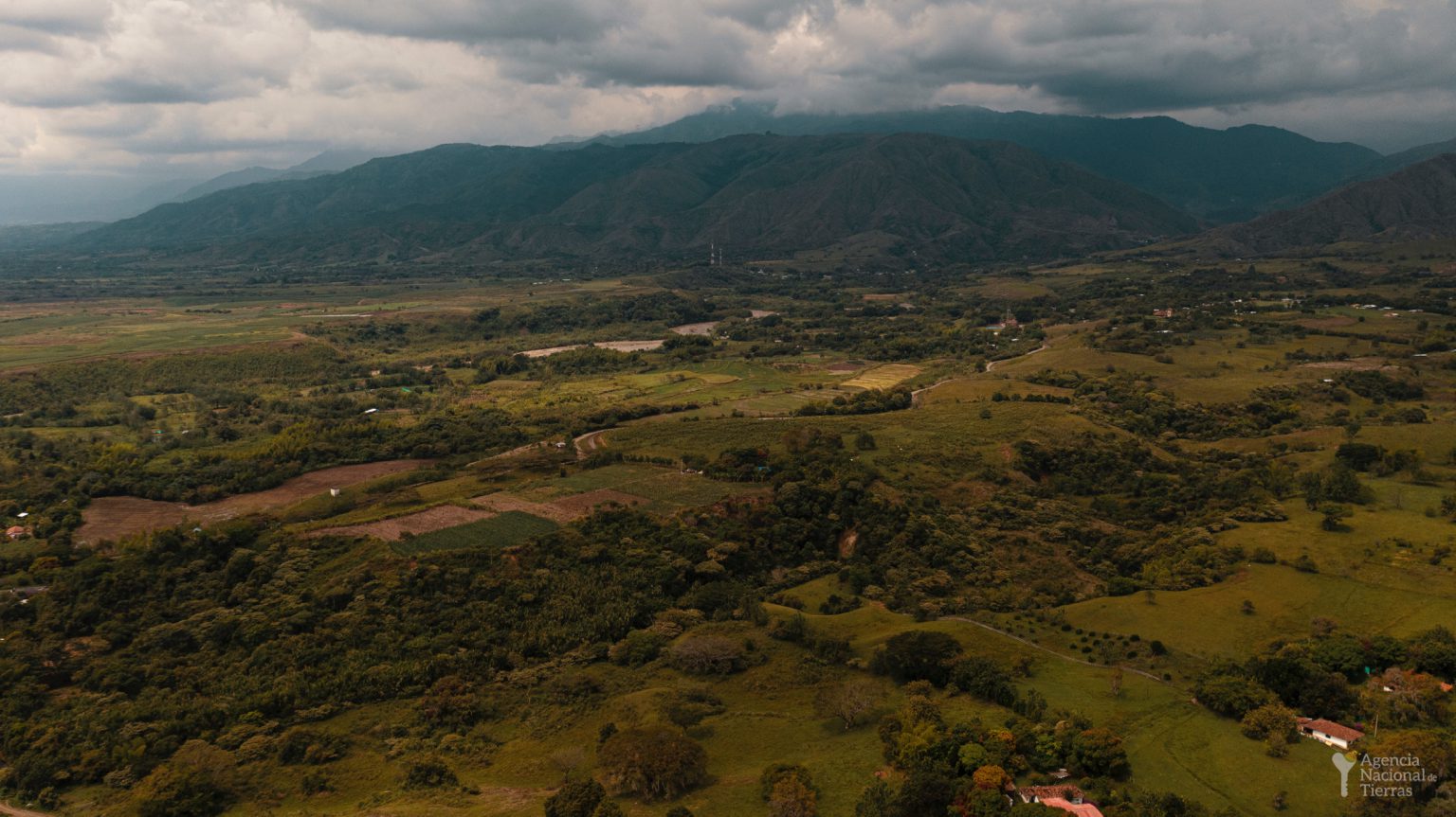 Fotografía aérea de un gran terreno con árboles y algunas casas.