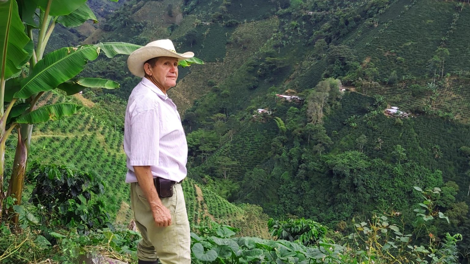 Señor campesino en las montañas donde hay algunas siembras.