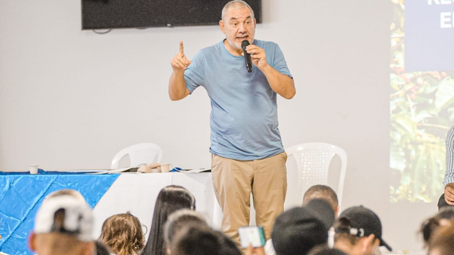 Gerarrdo Vega hablando con un micrófono frente a algunas personas