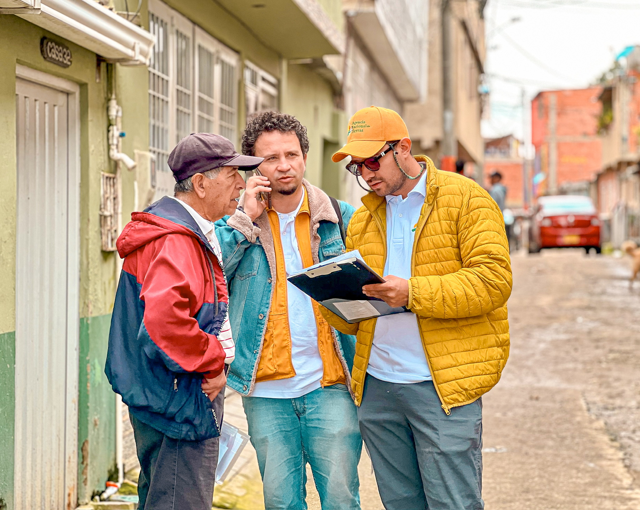 tres-hombres-parados-en-la-calle-mirando-un-portapapeles