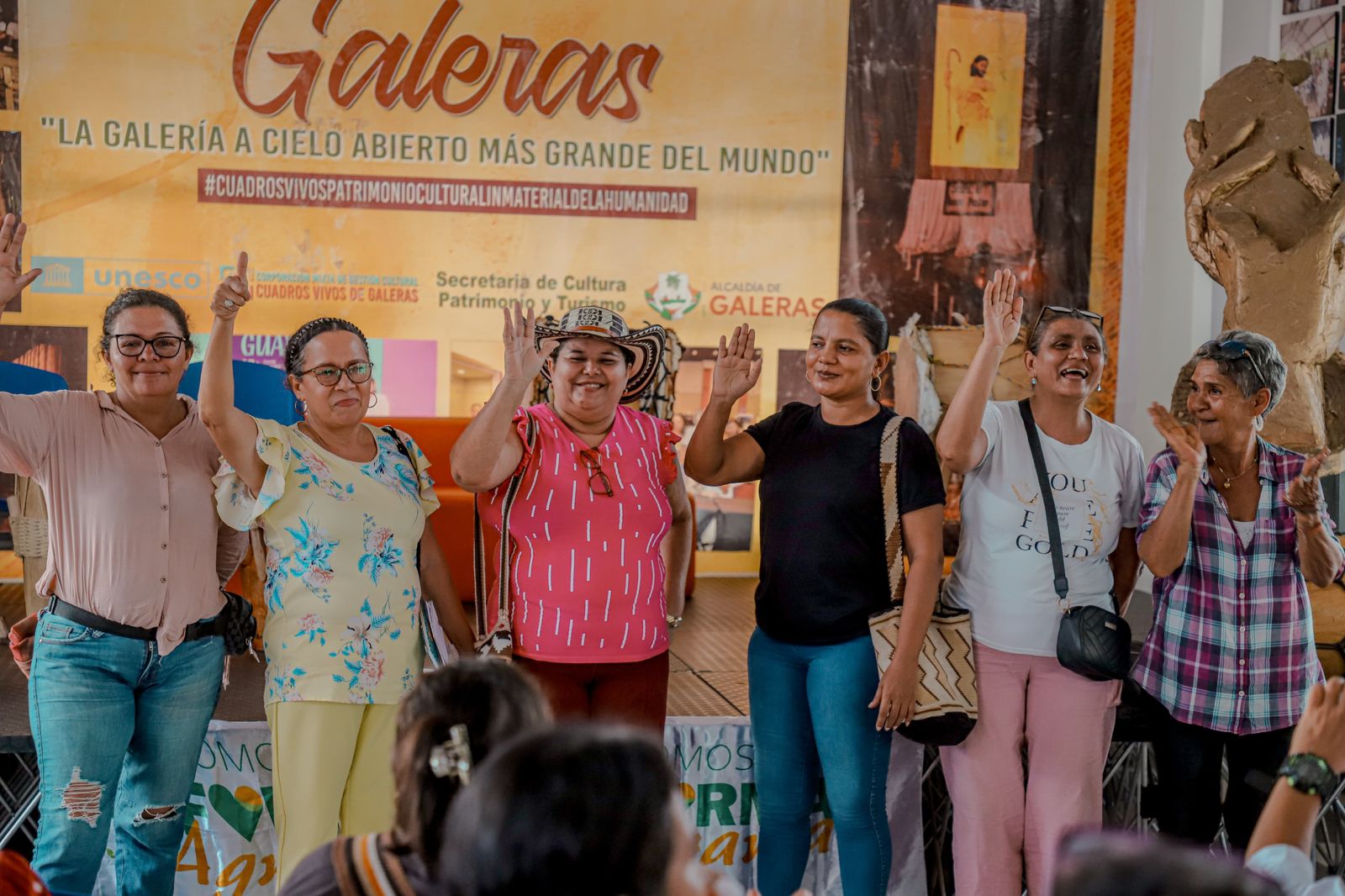 un-grupo-de-mujeres-parados-frente-a-un-banner