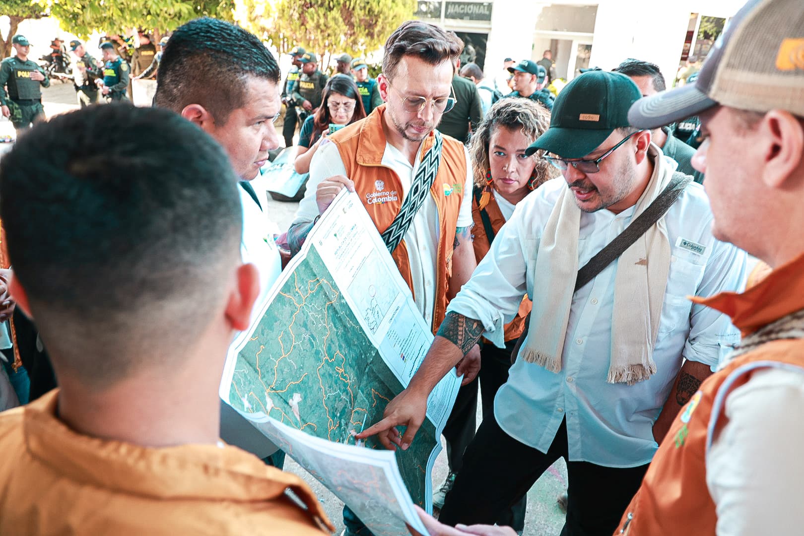 director-ant-con-un-grupo-de-personas-en-chalecos-naranjas-que-miran-un-mapa