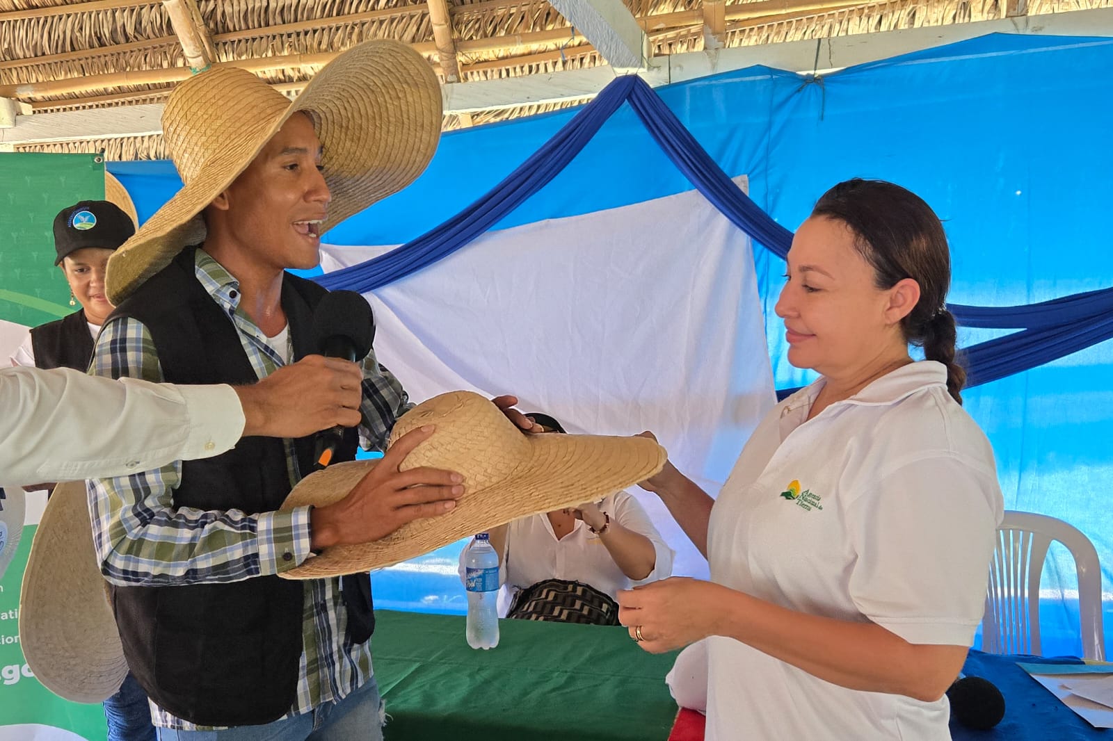 un-hombre-que-lleva-un-sombrero-de-paja-le-entrega-un-sombrero-a-una-mujer