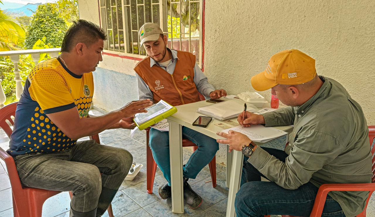 tres-hombres-sentados-en-una-mesa-con-papeles-y-boligrafo