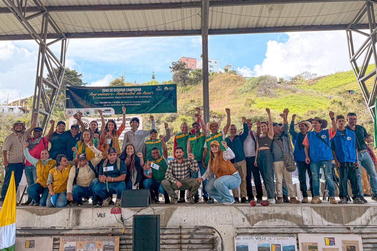 un-grupo-de-personas-paradas-en-un-escenario-con-las-manos-en-alto