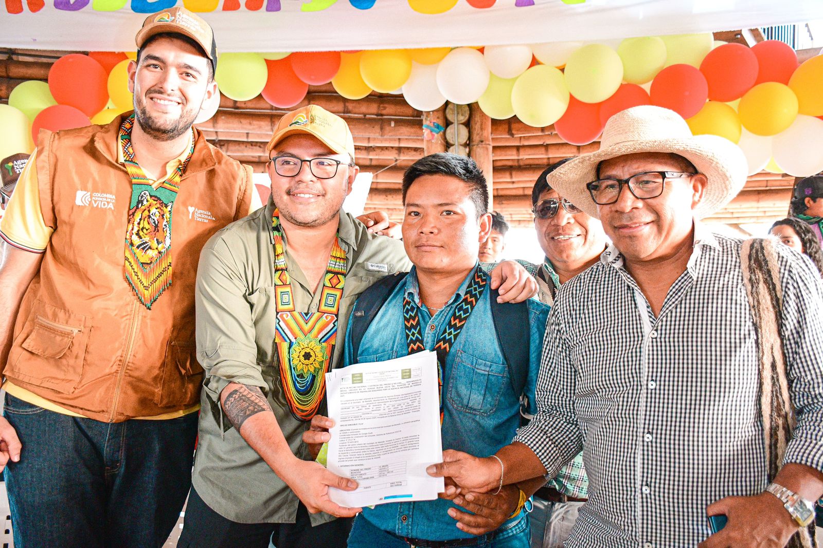 director-ant-junto-a-un-grupo-de-personas-paradas-sosteniendo-documento-de-tierras-ant