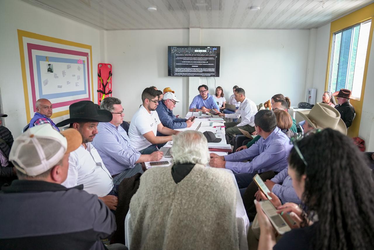 un-grupo-de-personas-sentadas-alrededor-de-una-mesa-con-papeles