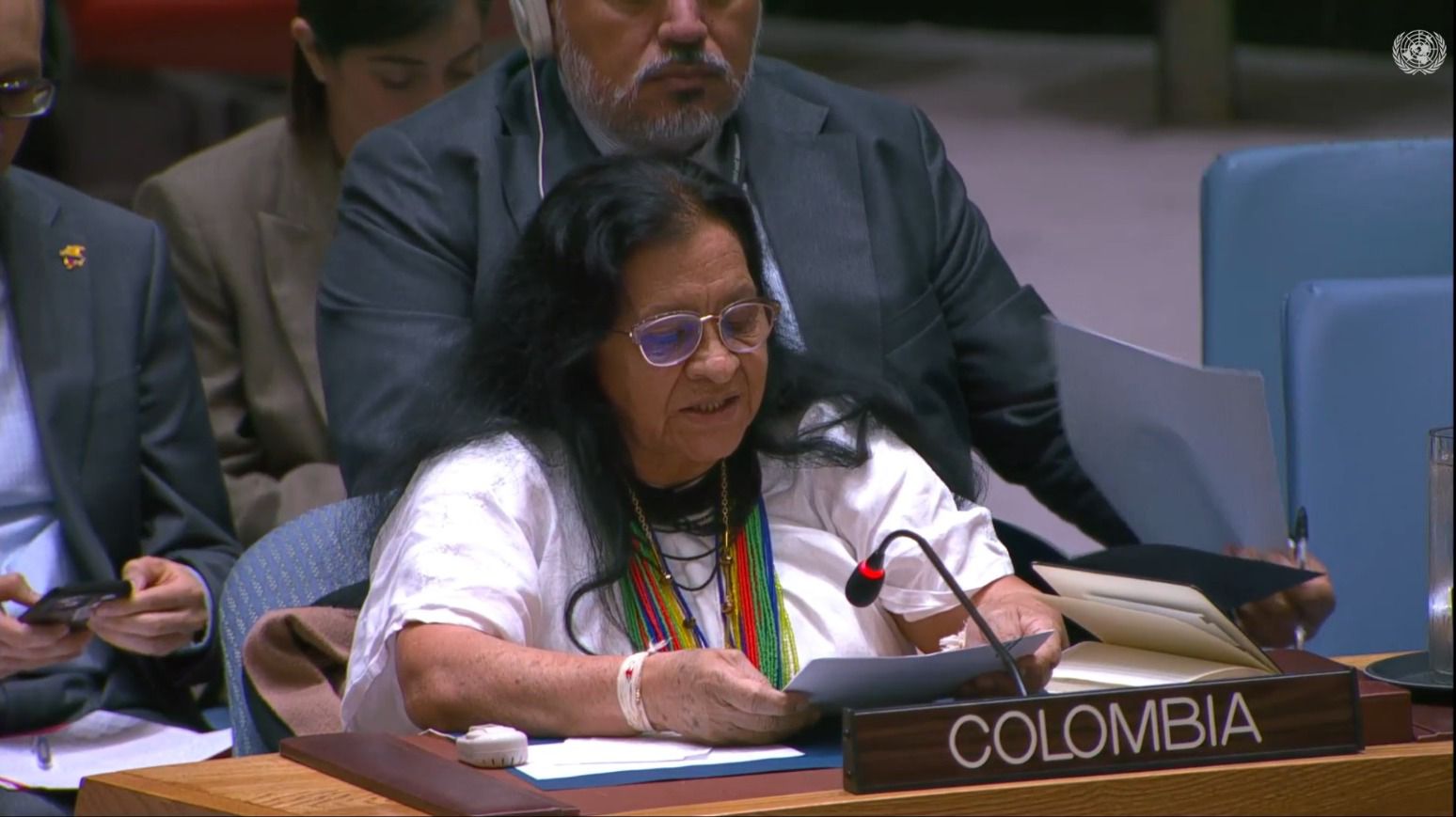 una-mujer-sentada-en-una-mesa-con-un-microfono-en-la-onu