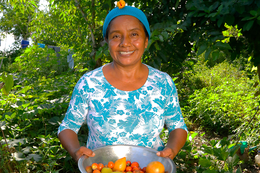 Mujer sonriendo con un plato de frutas