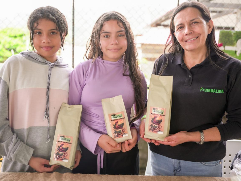 tres-mujeres-sosteniendo-bolsas-de-cafe-en-una-mesa