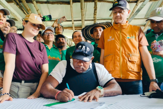 un-grupo-de-personas-parados-alrededor-de-una-mesa-firmando-papeles