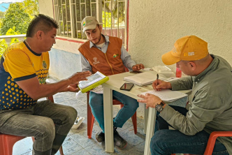 tres-hombres-sentados-en-una-mesa-con-papeles-y-boligrafo
