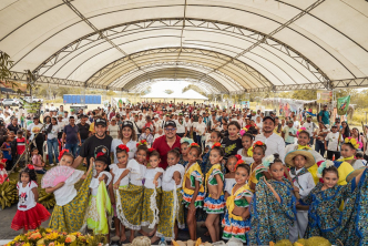 un-grupo-de-personas-vestidas-de-colores-de-pie-en-un-polideportivo