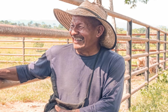 un-hombre-con-sombrero-parado-junto-a-una-valla