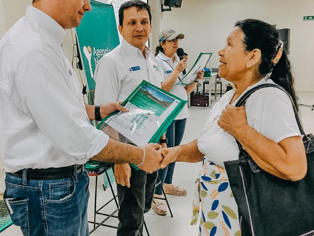 Un funcionario de la ANT entrega el título de propiedad a las manos de una mujer campesina en Puerto Libertador – Córdoba.