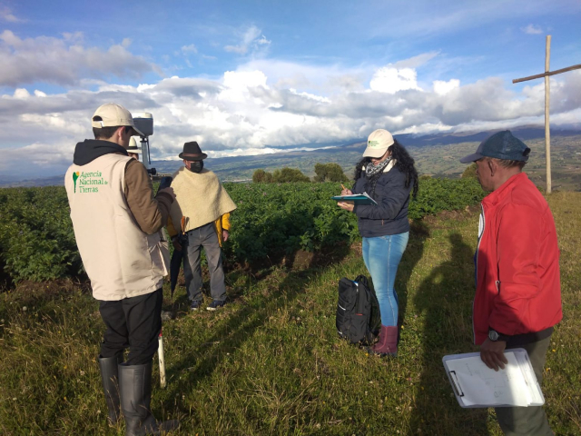Funcionarios de la ANT estudiando un terreno con zonas verdes.