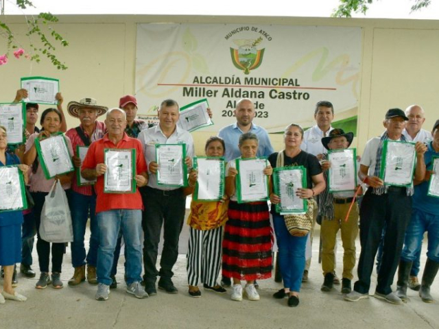 Beneficiados sosteniendo sus títulos en la alcaldía municipal del municipio de Ataco.