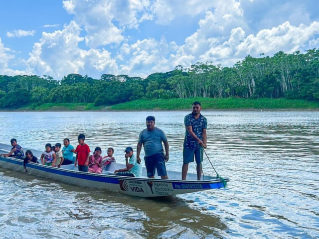 Pescadores y su familia en una lancha en un río.