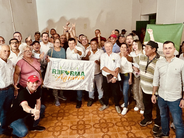 un-grupo-de-personas-parados-en-una-habitacion-con-un-banner-de-lant