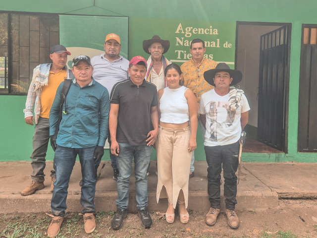 un-grupo-de-personas-parados-frente-a-un-edificio-verde
