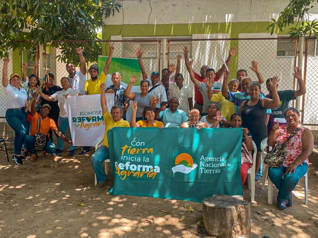 un-grupo-de-personas-posando-para-una-foto-con-un-banner-de-la-ant