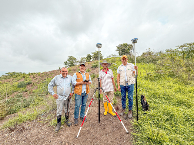cuatro-hombres-parados-en-una-ladera-con-un-tripode
