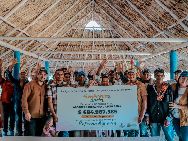 grupo-de-personas-paradas-frente-a-un-techo-de-paja