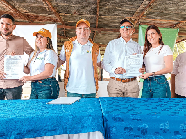 n-grupo-de-personas-de-pie-alrededor-de-una-mesa-recibiendo-documentos-de-tierras-entregadas