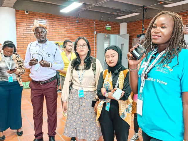 un-grupo-de-personas-de-pie-alrededor-de-una-mujer-hablando