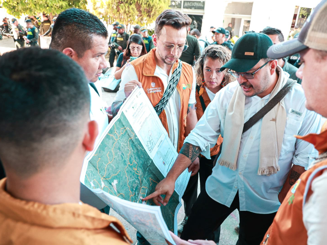 director-ant-con-un-grupo-de-personas-en-chalecos-naranjas-que-miran-un-mapa