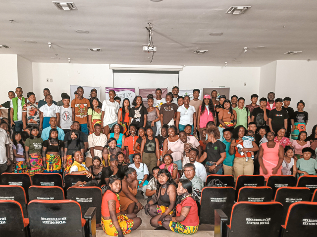 un-grupo-de-personas-posando-para-una-foto-frente-a-una-gran-audiencia