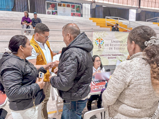 gente-de-pie-alrededor-de-una-mesa-con-un-letrero