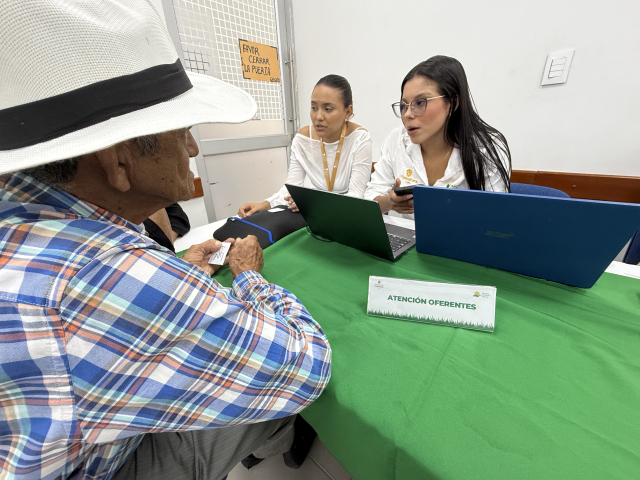 un-hombre-y-dos-mujeres-sentados-en-una-mesa-con-computadoras-portatil