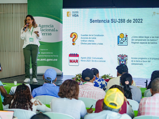 Mujer jóven presentando ante un auditorio.