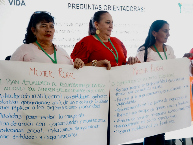 Asistentes sosteniendo una cartelera durante la presentación.