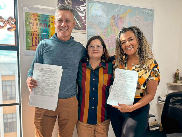 tres-personas-sosteniendo-papeles-frente-a-un-mapa