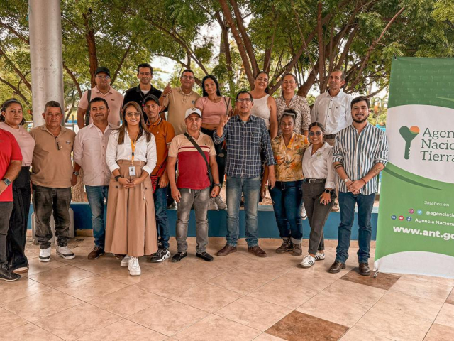 un-grupo-de-personas-paradas-frente-a-una-pancarta-de-ant