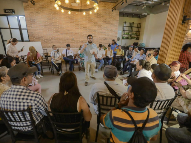 un-grupo-de-personas-sentadas-en-sillas-en-una-habitacion