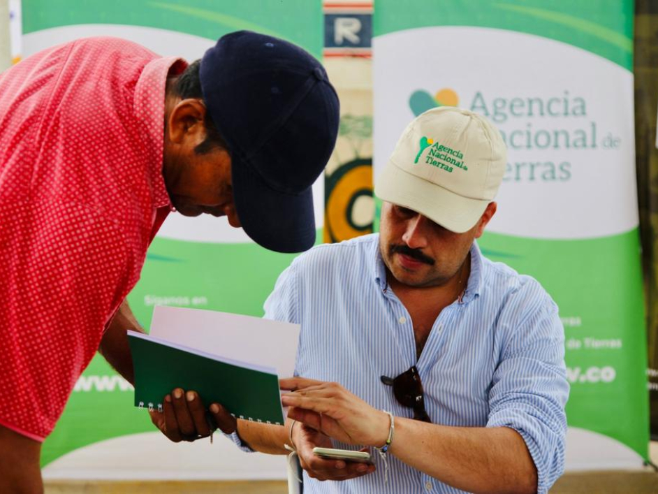 Funcionario de la ANT explicando algo a un señor asistente a la feria