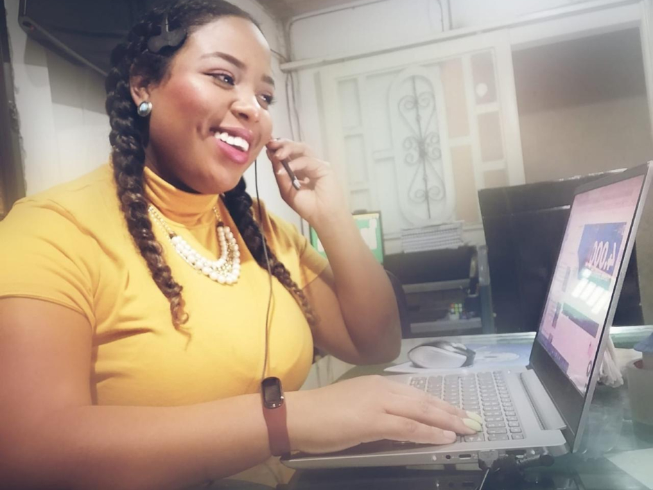 Mujer sonriente en computador atendiendo llamada 