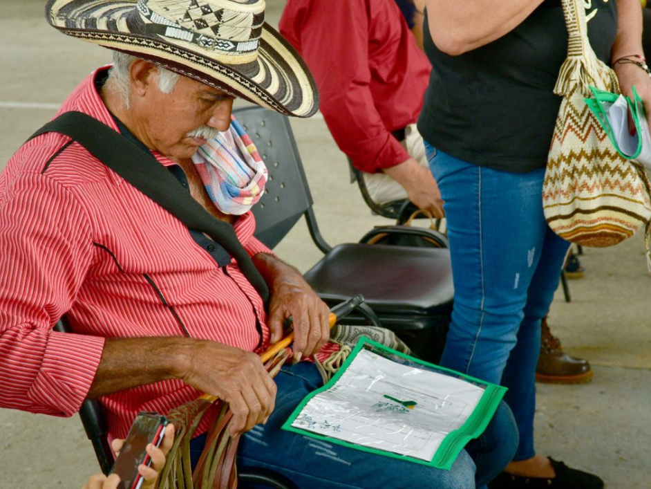 Campesino revisando el título que le entregaron.