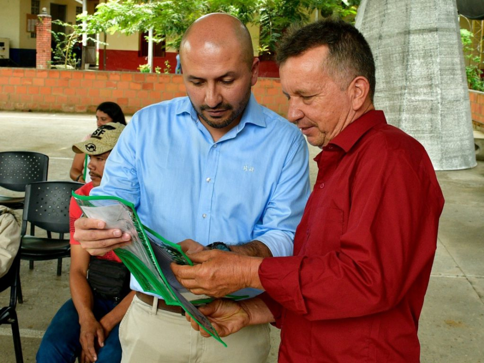 Dos señores revisando un documento.