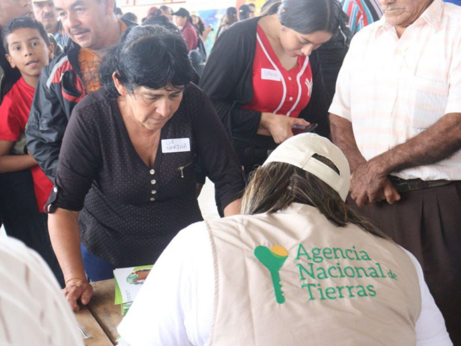 Funcionario de la ANT atendiendo las dudas de una fila de personas.