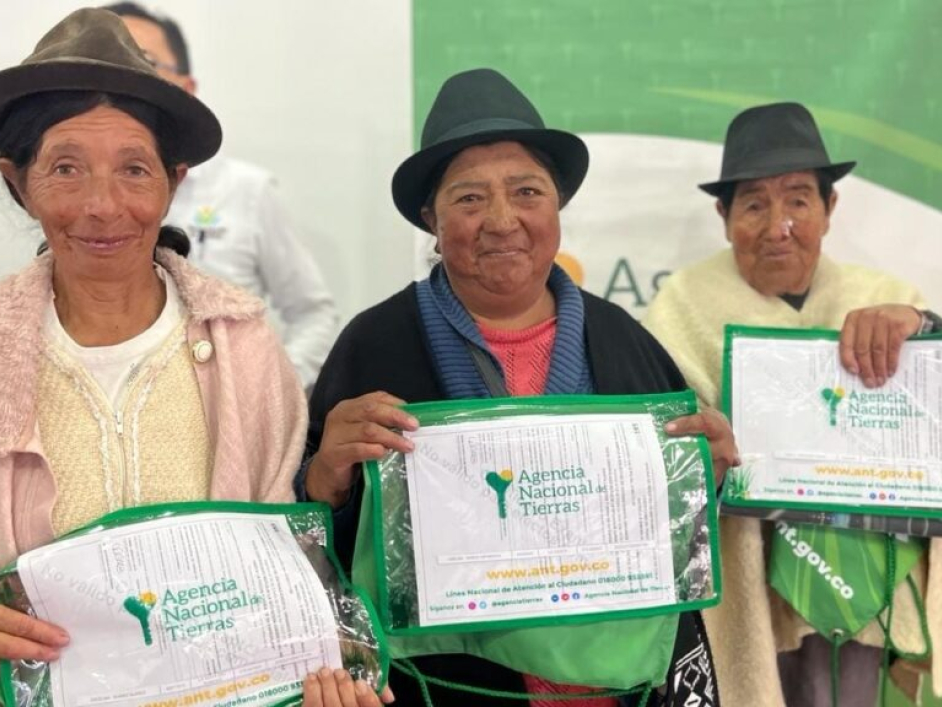 Tres mujeres campesinas recibiendo sus títulos.
