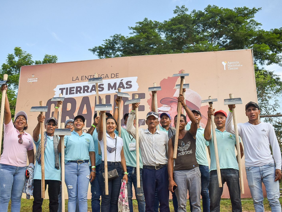 Grupo de personas celebrando alzando sus azadones.