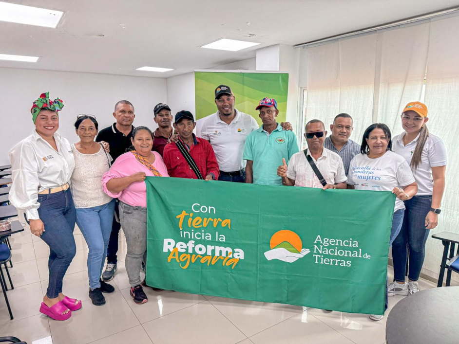un-grupo-de-personas-parados-frente-a-un-banner-de-la-reforma-agraria