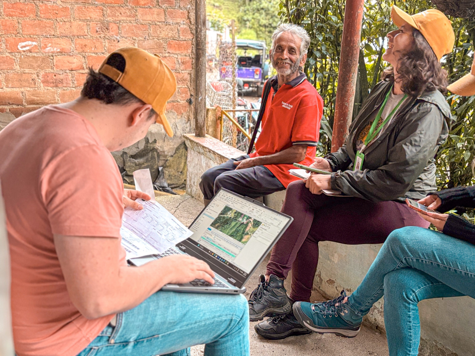 un-grupo-de-personas-sentadas-en-un-banco-con-computadoras-porttiles
