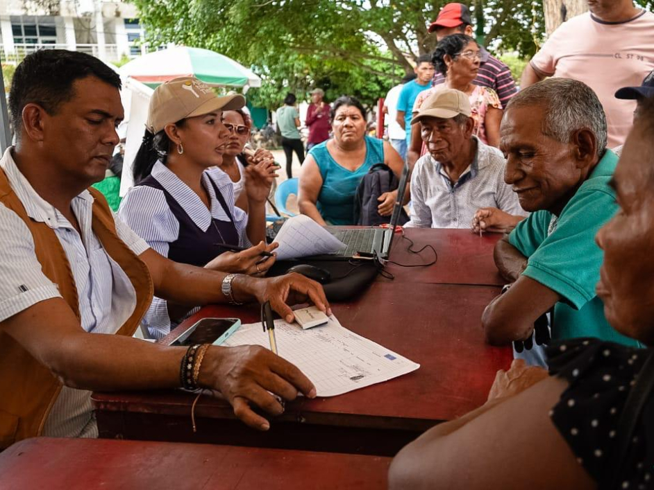 gente-sentada-en-una-mesa-con-papeles-y-un-hombre-firmando