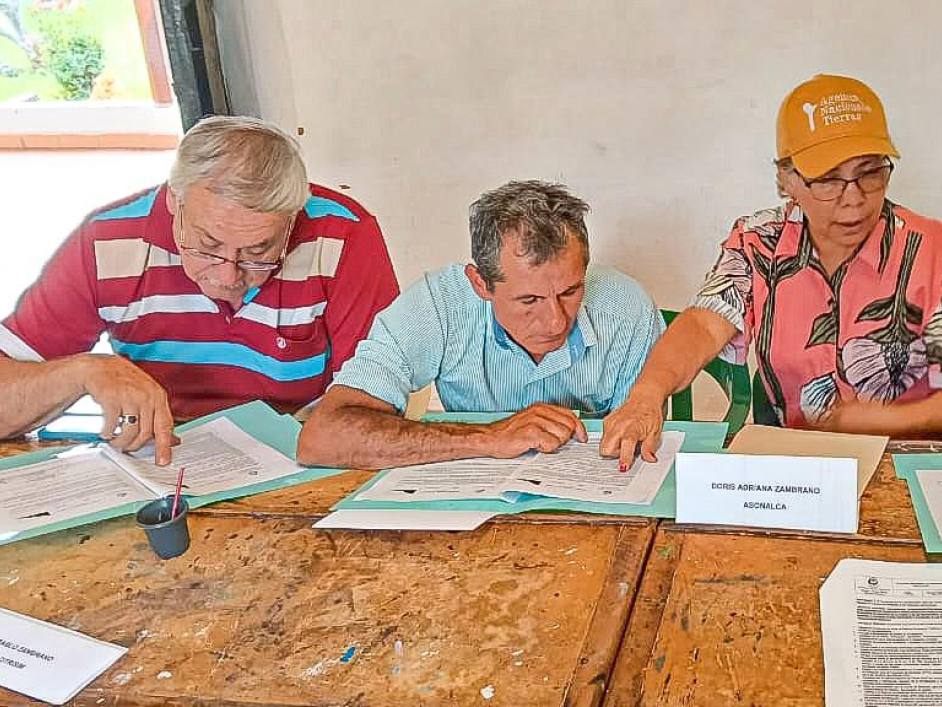 tres-personas-sentadas-en-una-mesa-con-papeles-y-bolgrafos