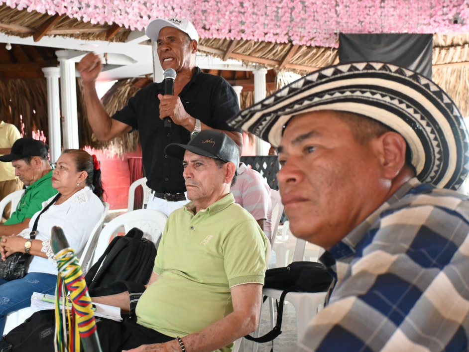 una-mujer-con-una-gorrao-y-una-camisa-blanca-sentada-en-una-mesa-con-una-senora